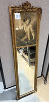 Full length view of antique trumeau mirror with visible upper lithograph and full mirror panel.