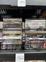 Top-down view of a large stack of DVDs including TV series and movies with visible spines.