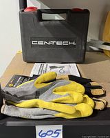 Closed black plastic carrying case with Cen-Tech printed on the front. Two pairs of large yellow and gray Western Safety gloves folded and laid on top, with the owner's manual partially visible behind.