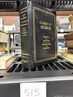 Front and spine cover of the hardcover Classics of Horror book showing gold embossed titles and decorative border.