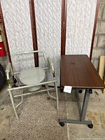 Steel commode and adjustable overbed table side by side showing full view of both items