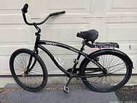 Side view of the black Genesis Onex 29 men's single speed cruiser bike showing frame geometry, seat, handlebar, and wheels.