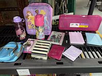 All items displayed together: lunch box, thermos, water bottle, pencil box, keychain, assorted notepads, and backpack.
