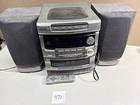 Full view of Emerson MS8007 stereo system with two external speakers and remote control placed in front.