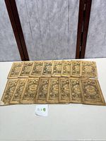 Photo showing 16 Old Farmers Almanacs laid out in two rows, displaying covers with decorative old-style illustrations and titles.