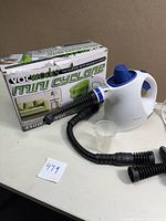 Vacworks Mini Cyclone mini vacuum with box and hose attachments on display