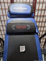 Close-up of blue and black padded headrest with Innova logo and heating/massage pad showing red heating icon.