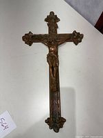Full view of large bronze crucifix cross showing the entire cross and Jesus figure.