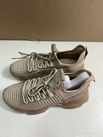 Side view of the left and right blush pink Maxima sneakers showing knit and mesh upper, laces and sole detail.