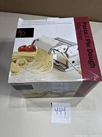 Box showing brand new sealed pasta and dough machine with product image and features.