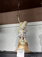 Full view of porcelain girl figural lamp showing figure, base, and lamp fixture
