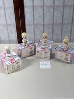 Four Precious Moments Little Moments figurines on original heart-themed boxes.