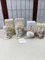 Four Precious Moments figurines and ornament with original boxes in background