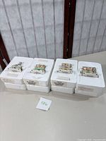 Four Precious Moments train collectibles in original white styrofoam packaging, showing artwork on each train car