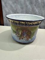 Blue and gold Rococo style urn with detailed painted pastoral scene on one side, gold handles and trim, in oval shape.