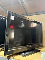 Front view of Sony 40-inch black tabletop TV showing screen and bezel with power indicator light on the lower bezel.