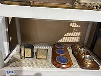 Lot of four vintage weather instruments on shelf including Airguide, Taylor Humidiguide, wooden plaque with instruments and small barometer.