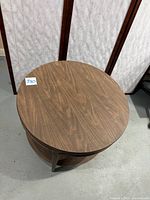 Top view of the round brown woodgrain Mersman side table, showing scratches and surface wear.
