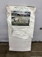 Packaged 4 ft wooden swing in box with product label and image showing natural wood swing with cushion on lawn.