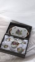 Full miniature tea set including teapot, sugar bowl, creamer, two cups with saucers, and a serving tray in a black box with white satin lining