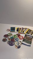 Photo showing a mixed collection of colorful pogs and several trading cards with comic-style images including Batman and other subjects.