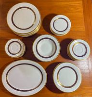 Overhead layout of plates, bowls and saucers on wooden table showing pattern and assortment