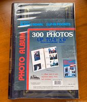 Shrink-wrapped album front with packaging label showing capacity, dimensions and model details.