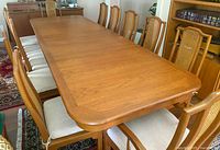 Extended teak table laid out with chairs at both sides