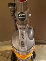 Front close-up of Dyson DC25 logo and brush attachment