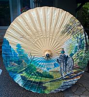 Hand painted umbrella canopy showing detailed scenic landscape with a man riding an elephant, lush greenery, and a river valley.