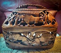 Frontal view of the intricately carved bread basket showing multiple animal carvings including a rhinoceros and other creatures with detailed openwork design.
