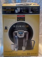 Front of sealed box showing brewer, carafe and pod counts