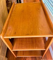 Top-down view showing rectangular top shelf with raised edges and teak grain