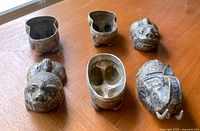 Three metal animal-shaped storage boxes shown separated at their midsections to reveal inside compartments. Two lions and one elephant figure all with intricate engravings.