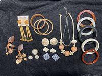 Full lot arranged on dark fabric showing bracelets, earrings, and necklaces as sold