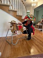 Overall shot showing the spring toy horse with Mexican style clothing and accessories worn by model.