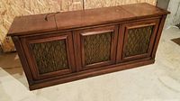 Full view of vintage Clairtone wooden console stereo cabinet with lattice speaker grills covering front speakers.