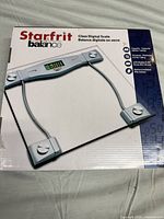 Starfrit Glass Digital Bathroom Scale in original packaging, showing scale with tempered glass platform and LED display