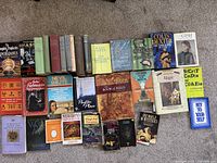 Overview of 29 books laid out across floor showing varying subjects such as prophecy, magick, astrology, Tolstoy's writings, and biographies.