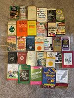 Photo showing assortment of 26 health, cleaning, nutrition, and cooking books including natural remedies and wellness titles.