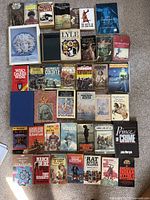 Photo showing entire lot of approximately 37 historical and military books arranged on carpet floor.
