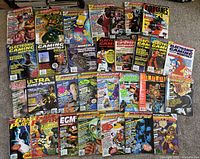 Photo showing 28 retro gaming magazines laid out on carpet, featuring titles such as Electronic Gaming Monthly, GamePro, Game Player's, Ultra Game Players, and EGM, with colorful covers depicting video game and pop culture artwork.