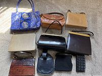 Photo showing nine assorted handbags and small cases arranged on the floor under sunlight.