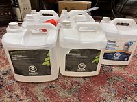 Six and a half 9.46L kerosene jugs with hazard labels. Siphon pump placed on top of jugs.