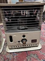 Single Sunbeam beige kerosene heater with metal grille and control knob on front base, showing brand label and details of the wick area.