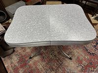 Table top in closed position showing grey marbled laminate surface and chrome edging