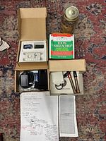Full view of silver water making kit components arranged on patterned rug including Mason jar with distilled water, pulser boxes, green coffee filters, silver rods, and instruction sheet.