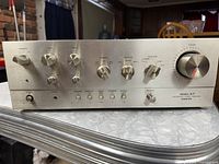 Front view showing brushed aluminum panel with volume, balance and tone controls