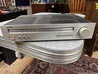 Front view of Yamaha T-550 tuner showing tuning scale, control buttons, and large tuning knob on a silver table.