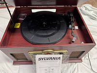 Open lid showing turntable component and included manual.